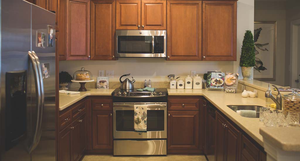 A cozy kitchen with wooden cabinets, featuring a microwave and oven.