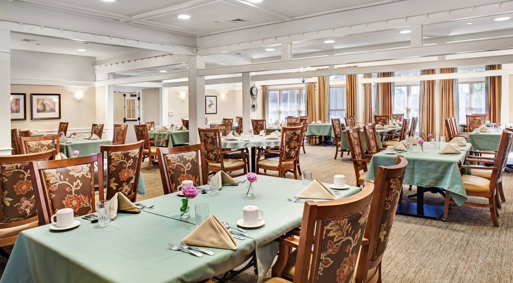 An elegantly set dining room with neatly arranged tables and chairs.