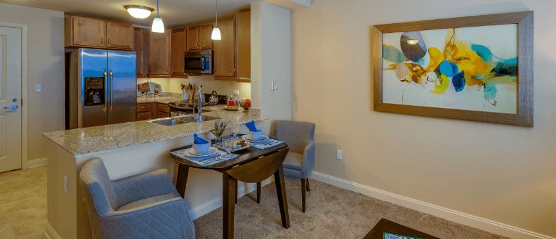 A cozy dining area with a modern kitchen in the background, featuring a neatly set table and stylish furniture.