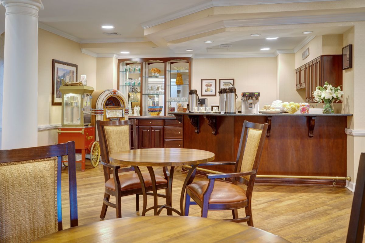A cozy cafe interior with wooden tables and chairs, featuring a counter in the background.