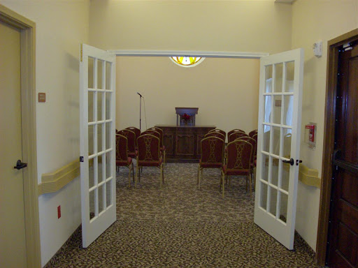 A view of a formal meeting space with chairs arranged neatly and a podium at the front.
