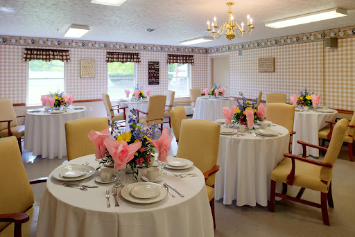 An elegantly set dining area featuring beautifully arranged tables with floral centerpieces.