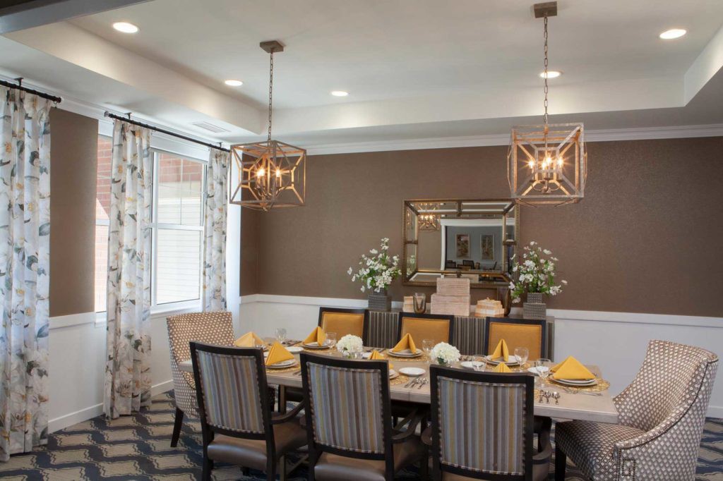 An elegant dining room with stylish chandeliers and a beautifully set table.