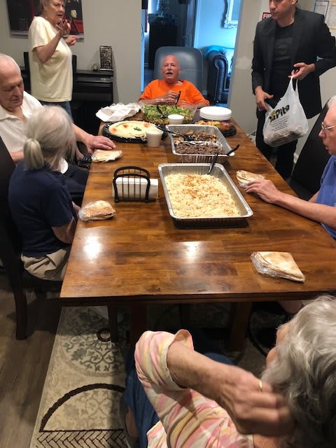 A family gathered around a dinner table enjoying a meal together.