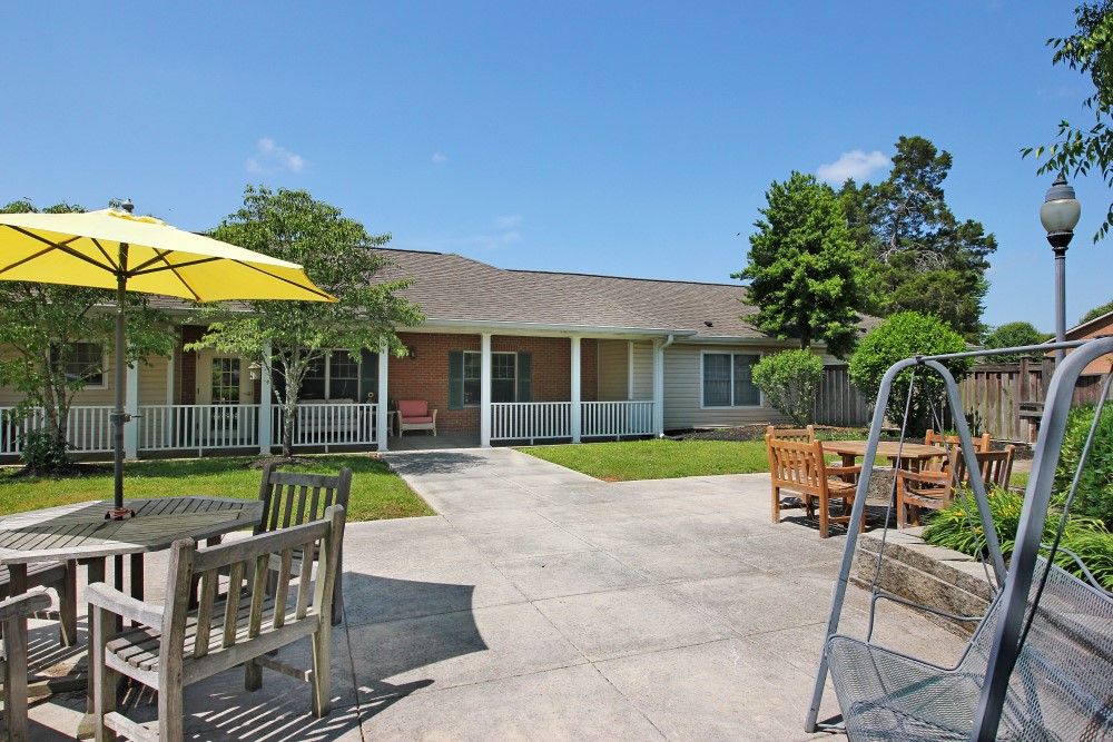A sunny backyard with patio furniture and a view of the house.