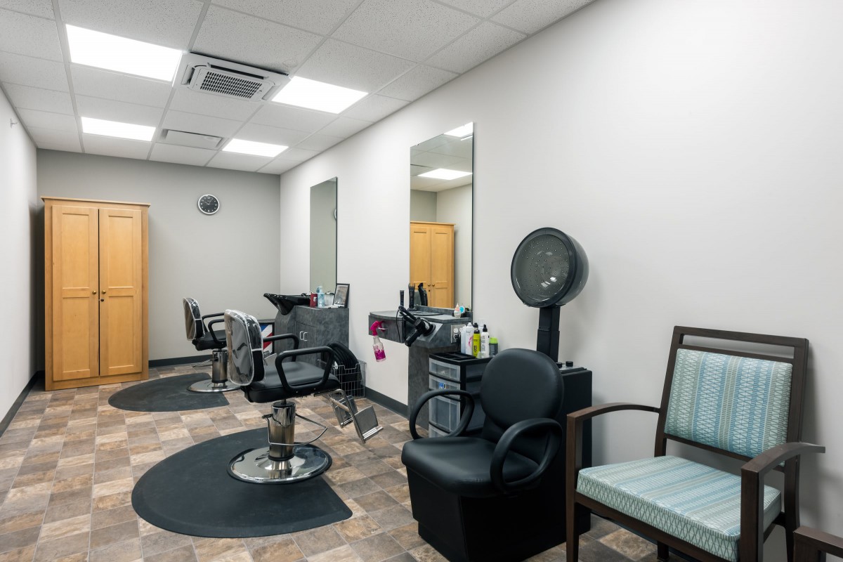 A modern and well-organized hair salon interior with chairs and mirrors.