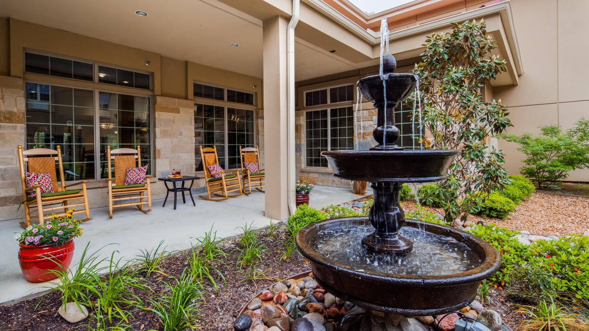 A serene courtyard featuring a multi-tiered fountain and comfortable outdoor seating.