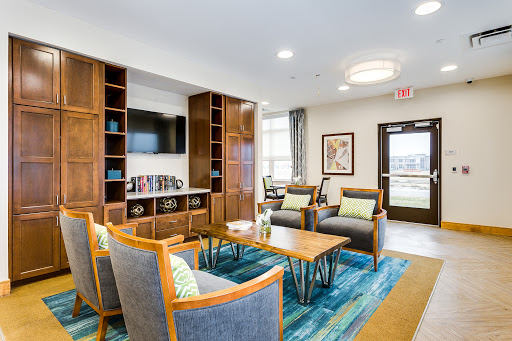 A modern lounge area featuring comfortable seating, bookshelves, and a television, designed for relaxation and social interaction.