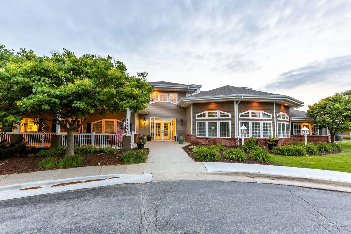 A large, luxurious house with well-maintained landscaping and a prominent driveway.