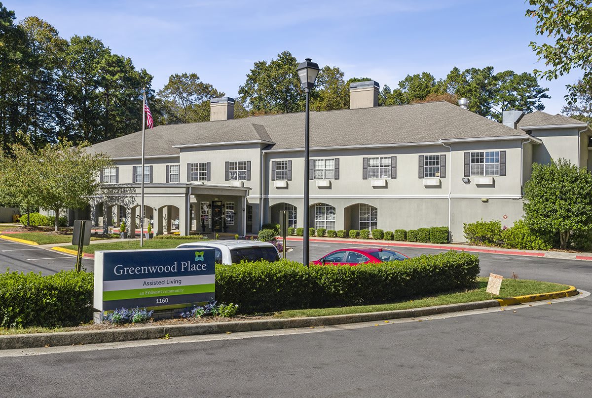 A hospital building with a parking area and surrounding greenery.