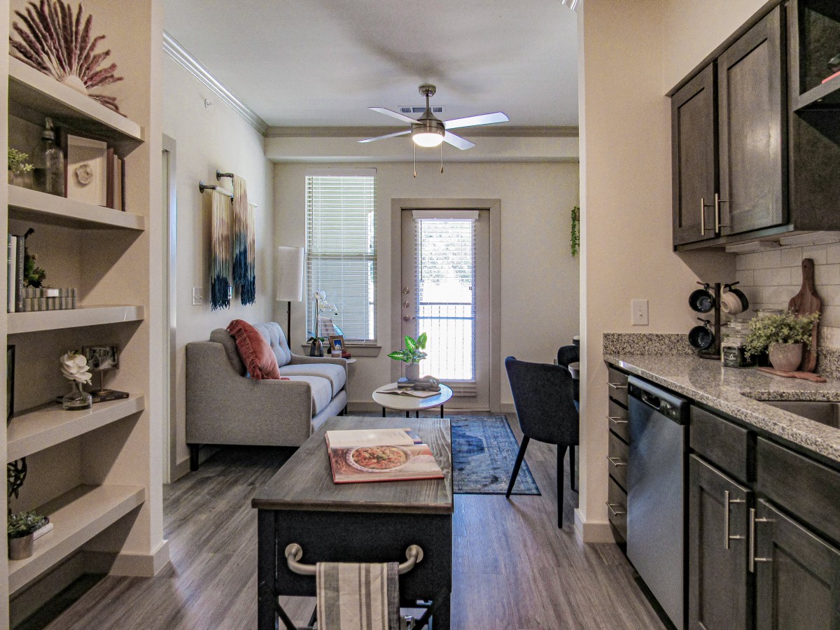 A cozy, modern apartment featuring an open living room and kitchen area with stylish furnishings.