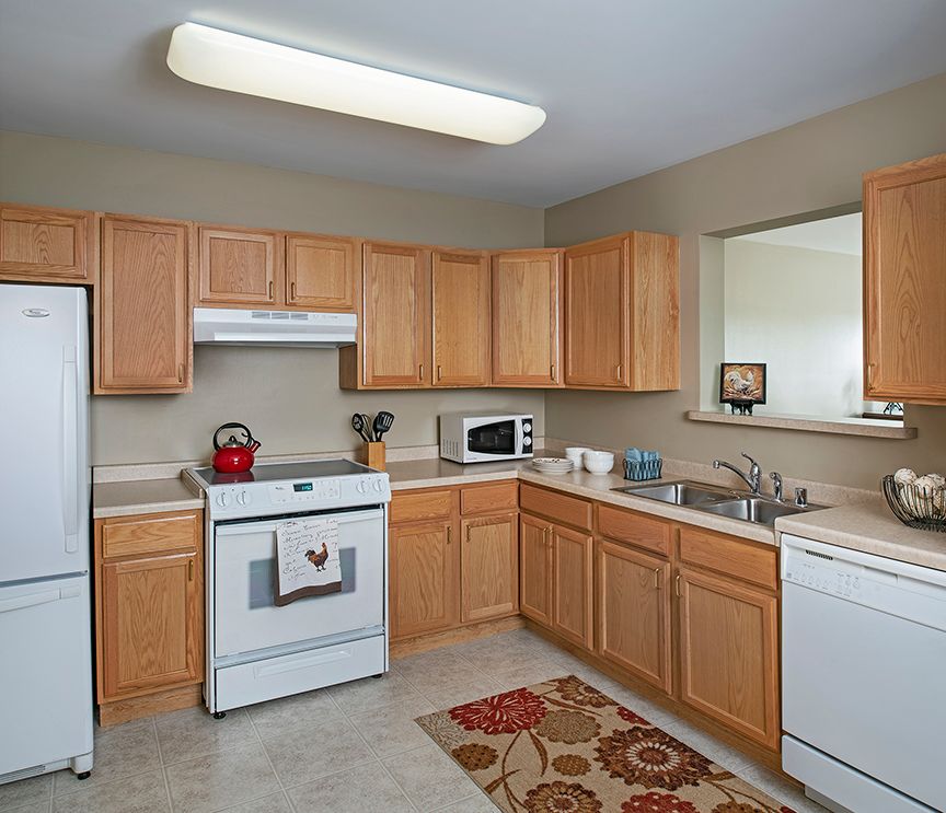 A modern kitchen with wooden cabinets and essential appliances.