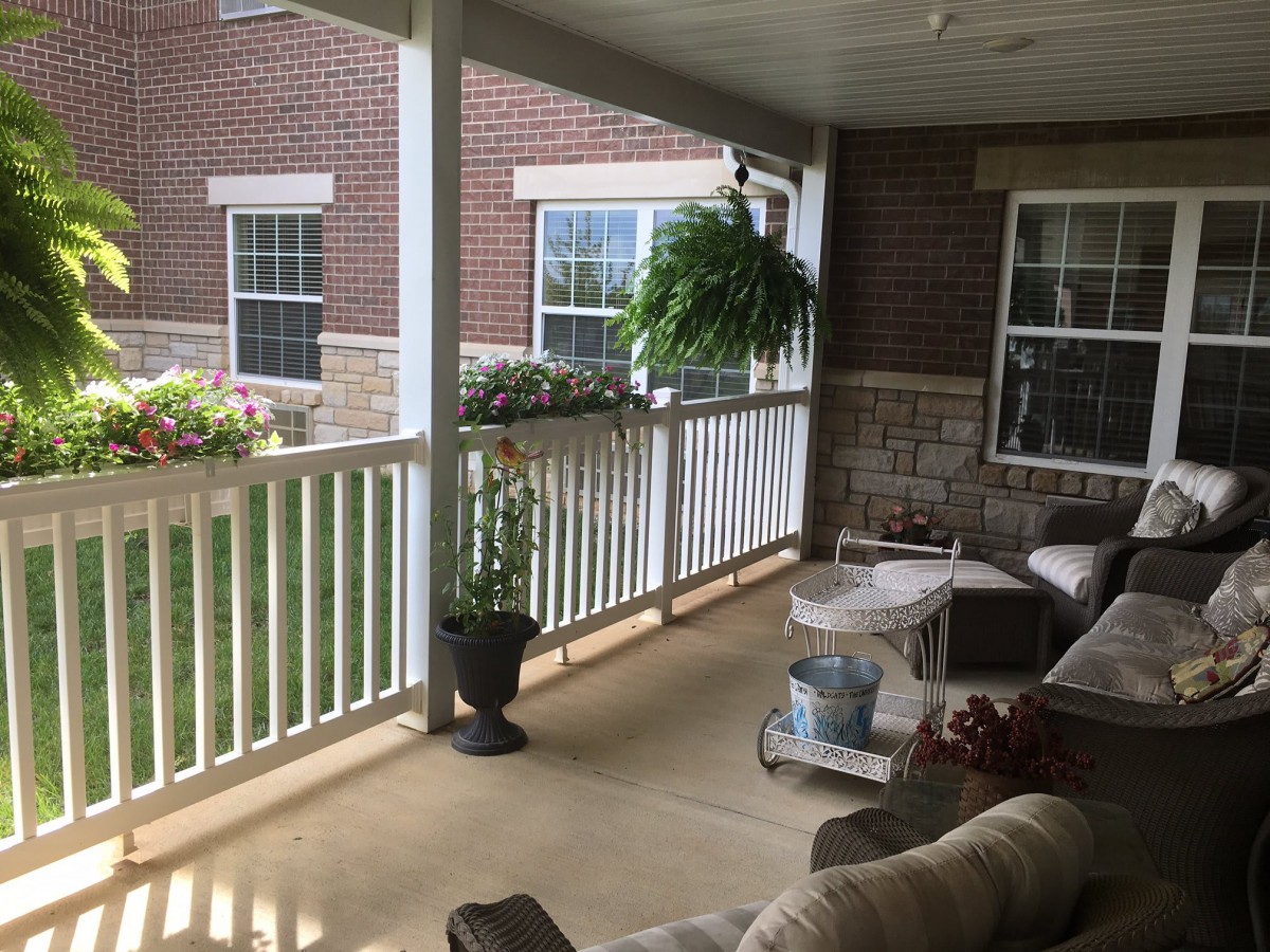 A cozy porch with furniture and plants, providing a relaxing outdoor space.