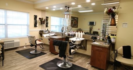 A well-equipped hair salon interior with chairs, mirrors, and hair styling stations.