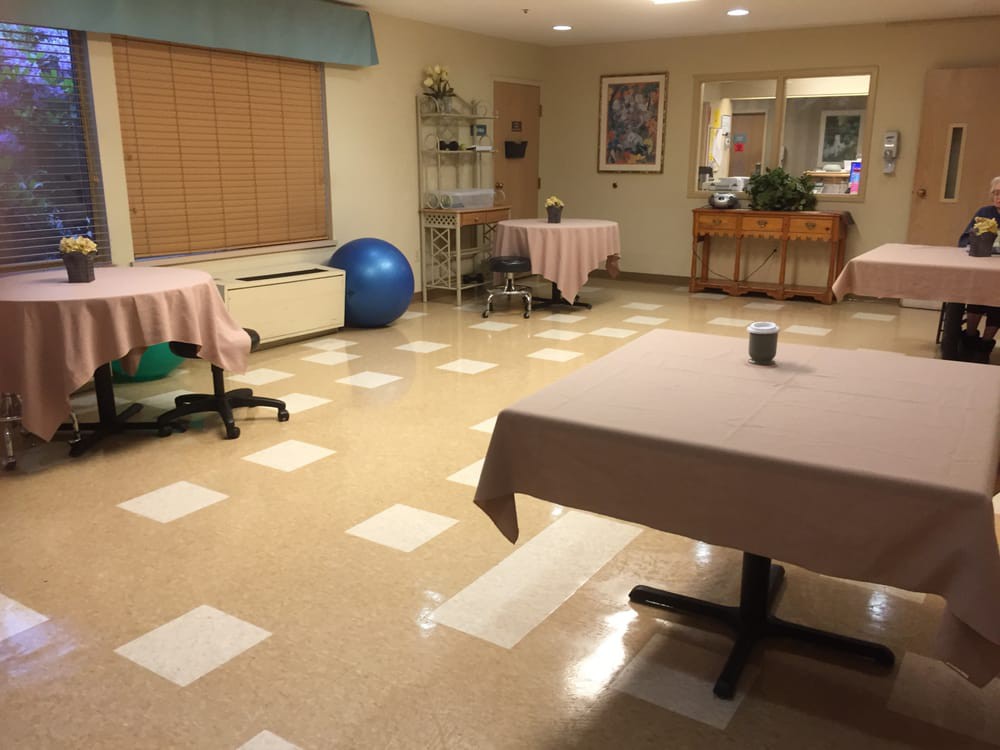 A rehabilitation room with exercise equipment and tables for therapy.