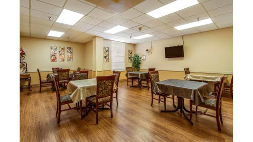 A cozy dining area featuring tables and chairs, complemented by wooden flooring and decorative wall art.