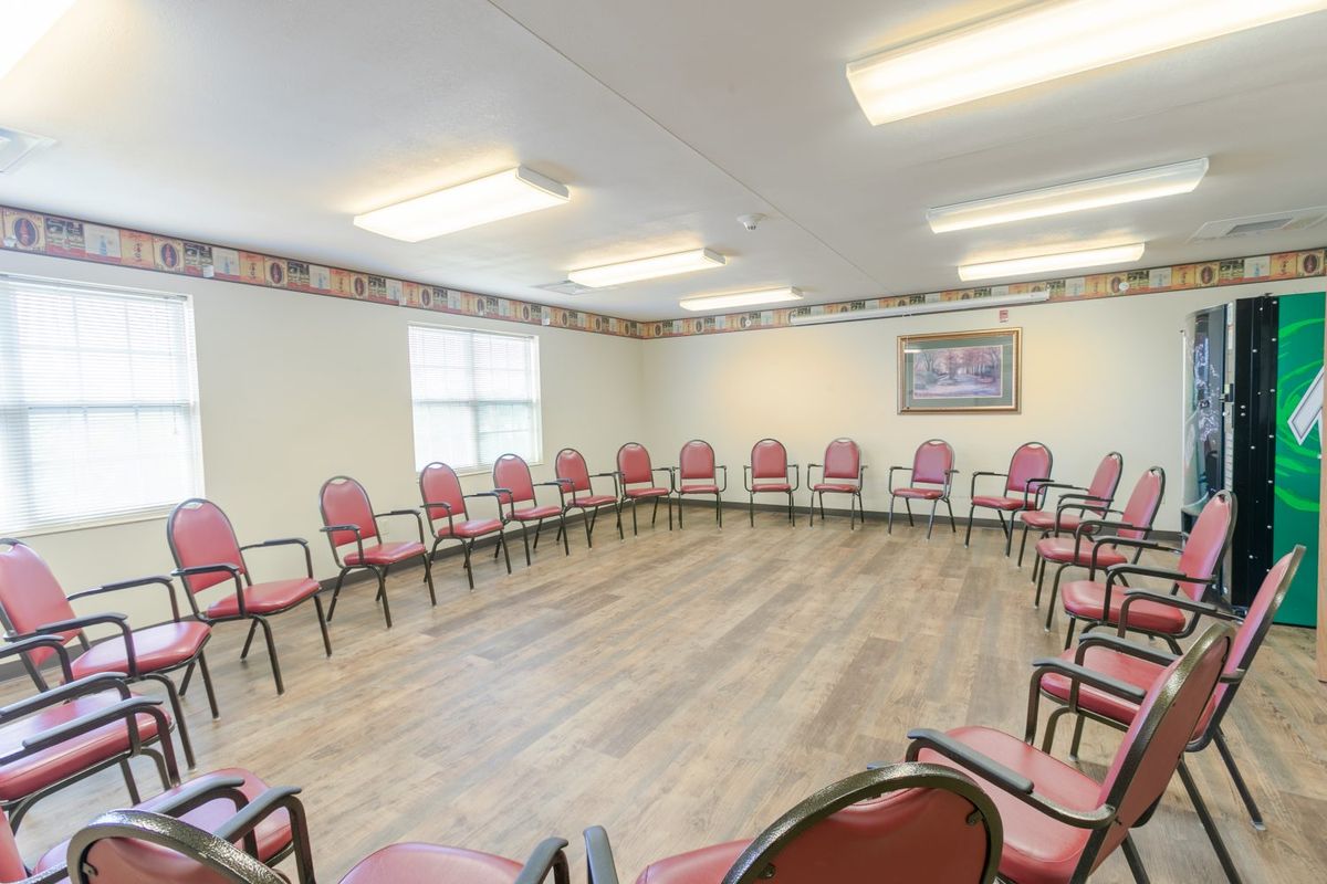 An empty meeting room arranged with chairs in a circle.