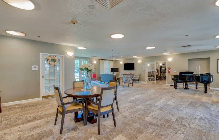 A modern communal living space with comfortable seating and tables, highlighted by ample lighting.