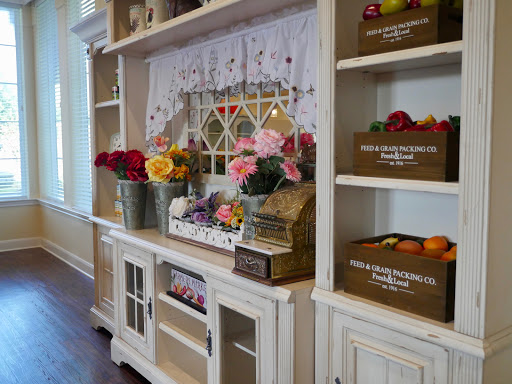 A beautifully arranged shelf showcasing vibrant flowers and decorative storage boxes, enhancing the cozy atmosphere of a home.