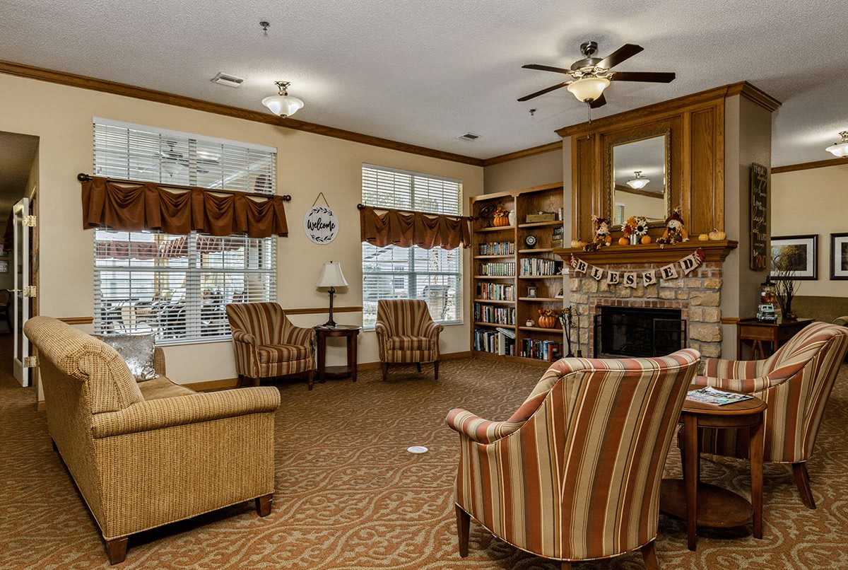 Cozy living room with a fireplace, bookshelves, and comfortable seating.
