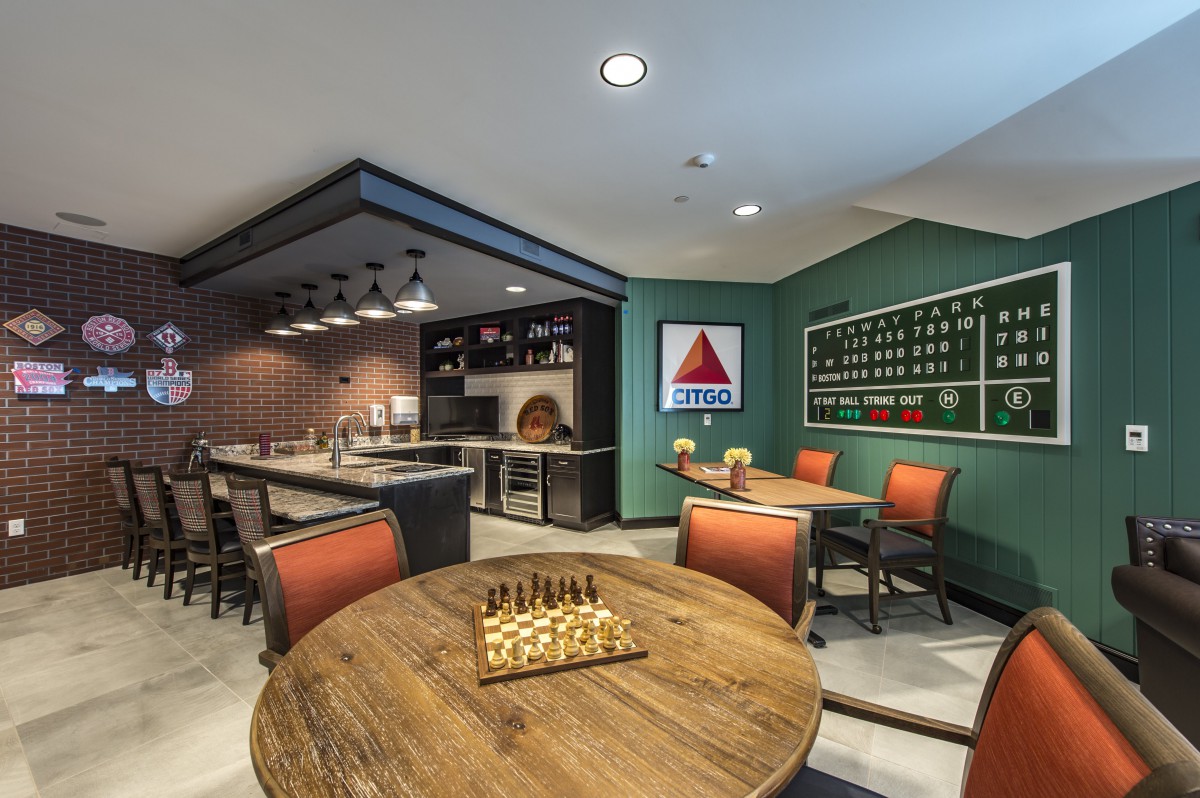 A modern game room featuring a chess board, pool table, bar area, and kitchenette.