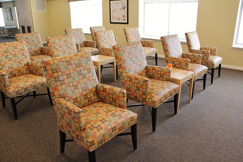 A neatly arranged waiting room with patterned upholstered chairs.