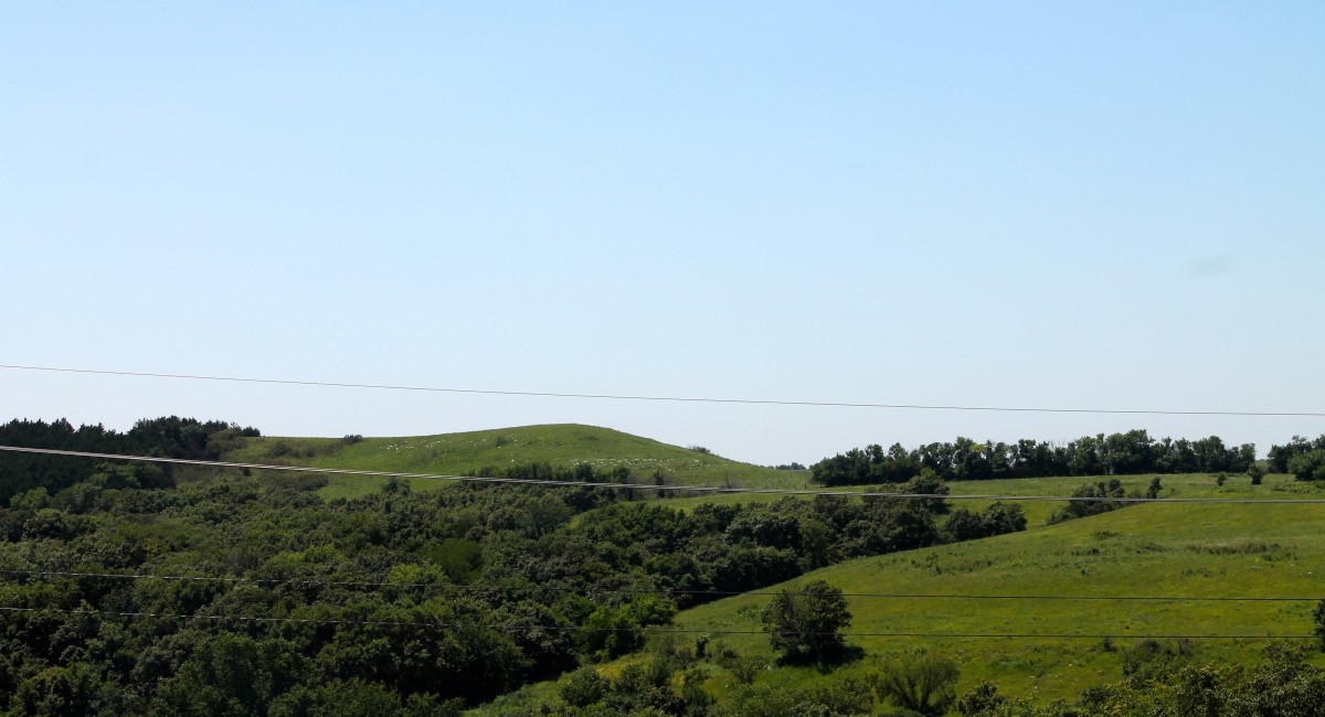 A scenic view of lush green hills under a clear blue sky.