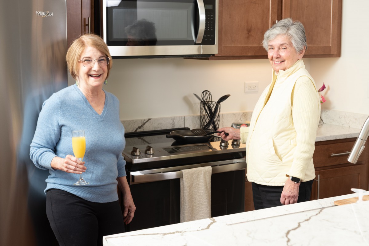 Two women enjoying time together in the kitchen.