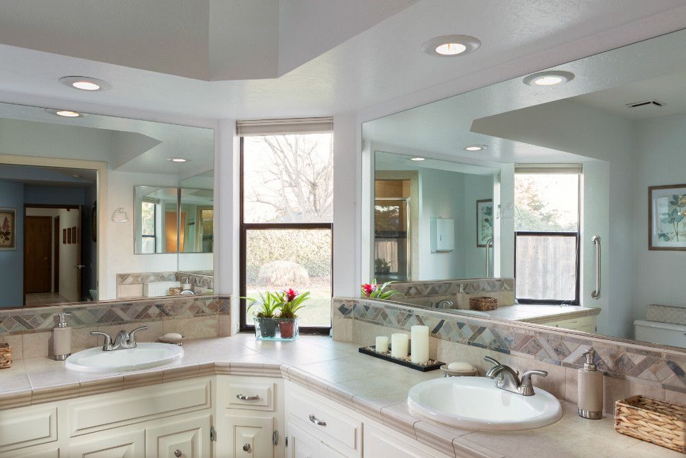A modern bathroom with large mirrors and stylish sinks.