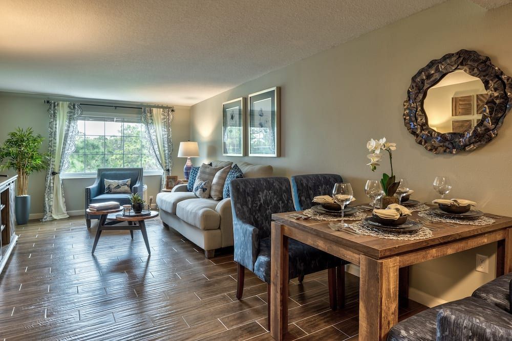 A cozy living and dining area with modern decor, featuring a comfortable sofa and wooden furniture.