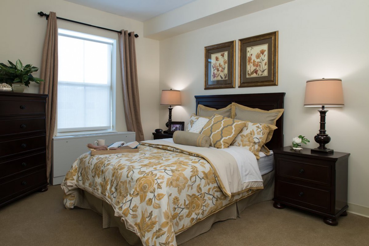 A cozy and well-decorated bedroom with floral bedding and soft lighting.