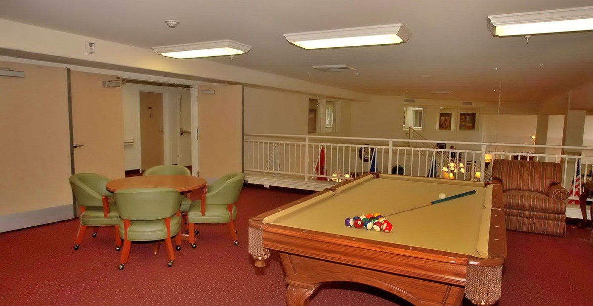 A cozy game room with a pool table and seating area.