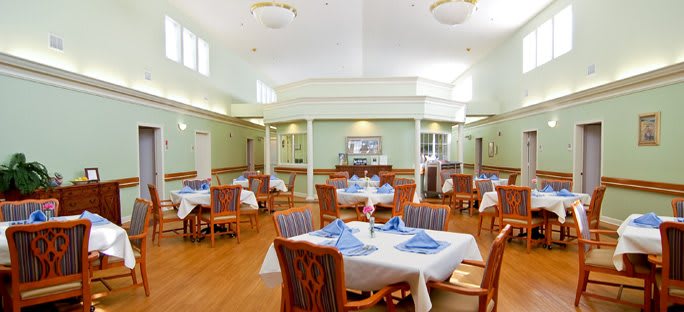 A bright and spacious dining room with neatly arranged tables and chairs.