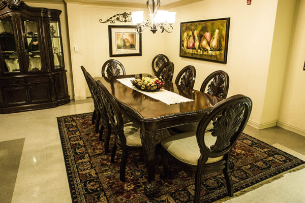 A traditional dining room with an elegant wooden table, chairs, and a chandelier.