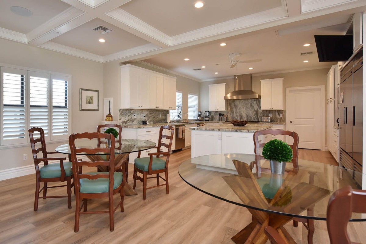 A modern open kitchen and dining area with wood flooring and stylish decor.