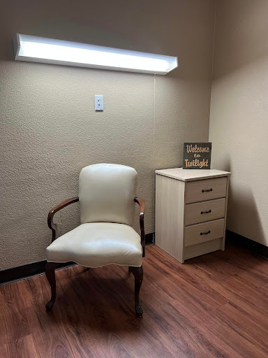 A simple office space featuring a chair and a small cabinet.