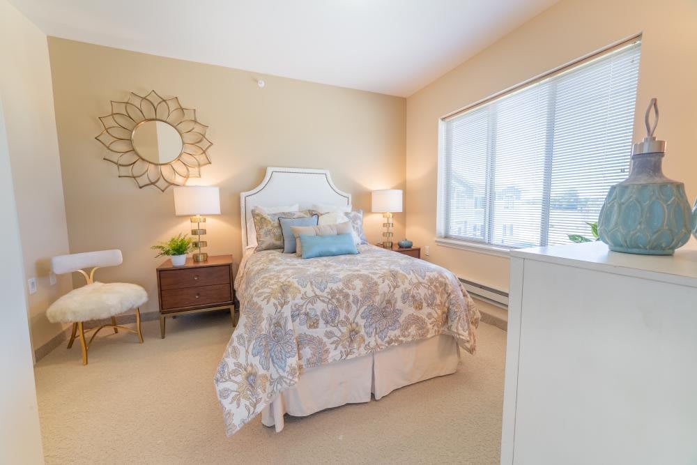 A cozy and elegantly decorated bedroom with a large window.