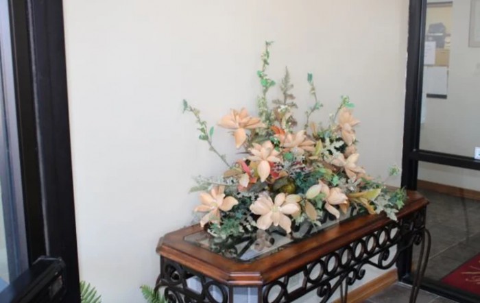 A decorative floral arrangement sits atop a wooden table, enhancing the indoor decor.