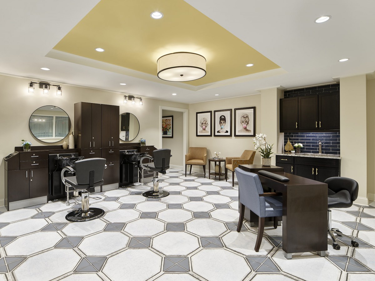Modern salon interior with stylish furnishings and geometric tile flooring.