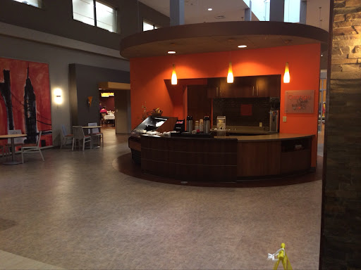 A modern reception area featuring a circular front desk and vibrant orange walls.