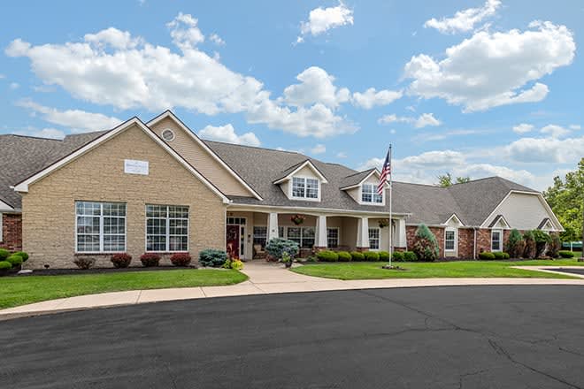 A suburban residential building with a well-maintained lawn and an American flag flying in front.
