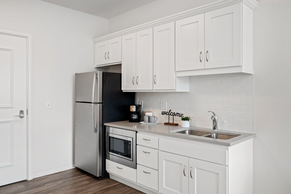 A modern kitchen with white cabinets and stainless steel appliances.