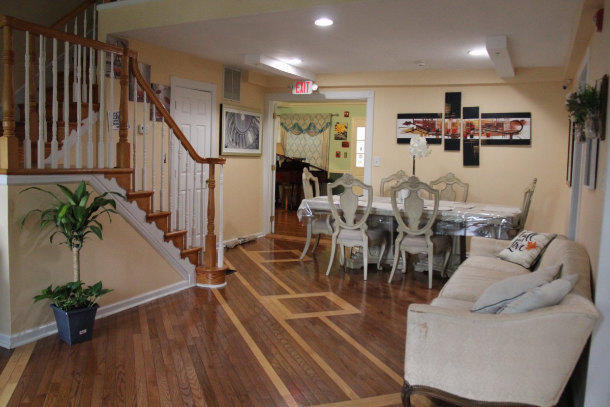 A cozy interior with a dining area and staircase, featuring elegant furniture and wooden flooring.