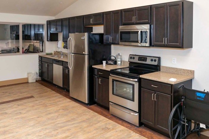Modern kitchen with stainless steel appliances and dark wood cabinets.