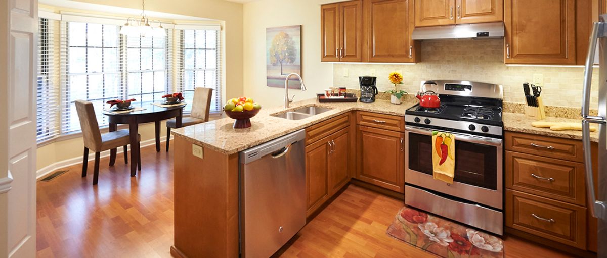 A modern kitchen with wooden cabinets and stainless steel appliances.