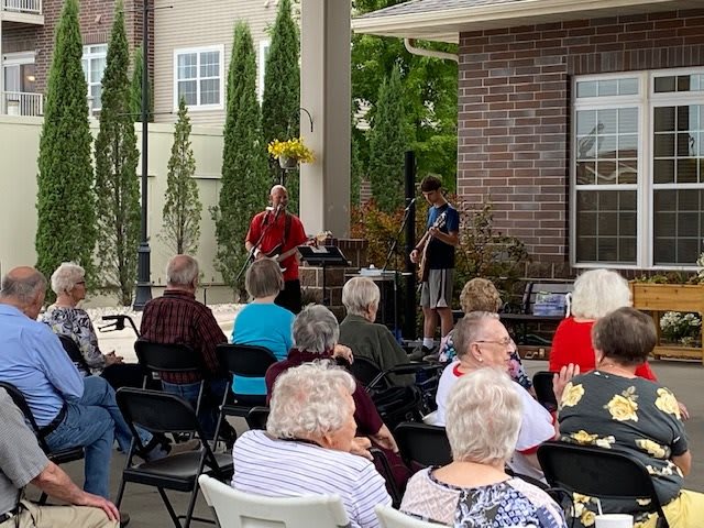 An outdoor event with a live music performance and audience.