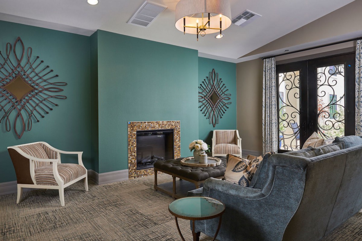 A cozy living room featuring a decorative fireplace, stylish furniture, and elegant wall accents.