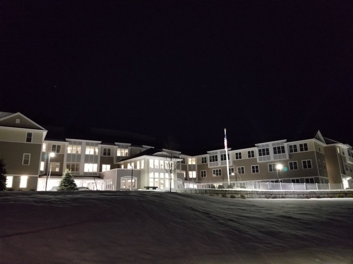 A well-lit building at night with visible entrance and windows.