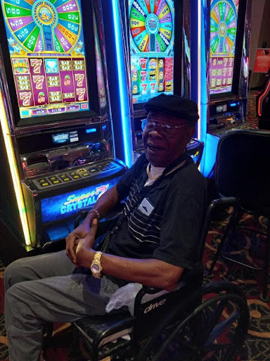 A person enjoying their time at a casino, seated next to slot machines.
