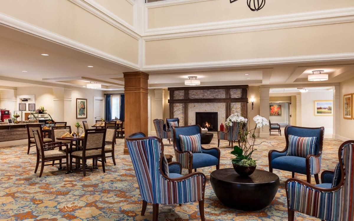 A luxurious lobby with comfortable seating around a central fireplace.